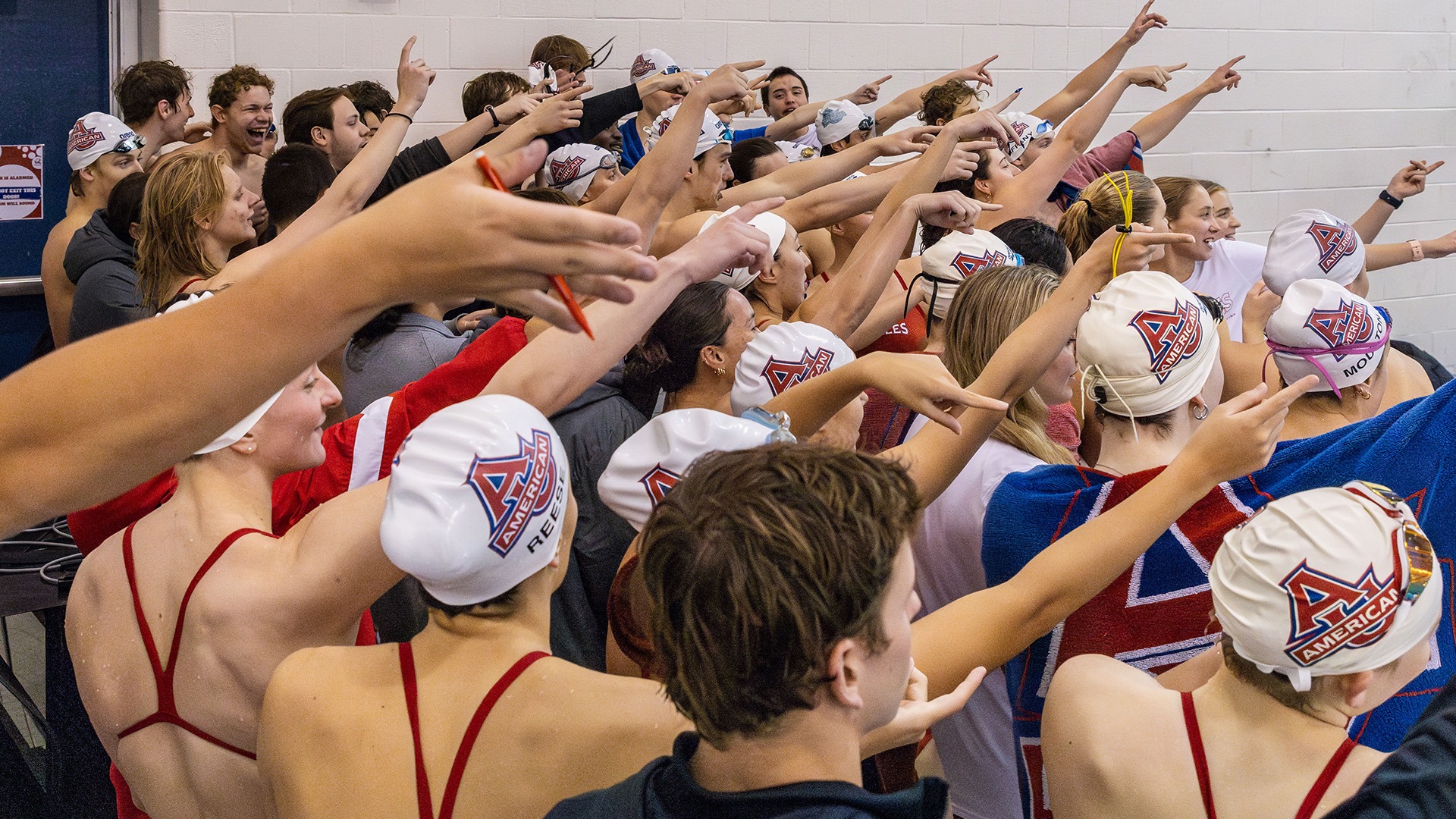 swimmers and divers doing a team cheer at a meet
