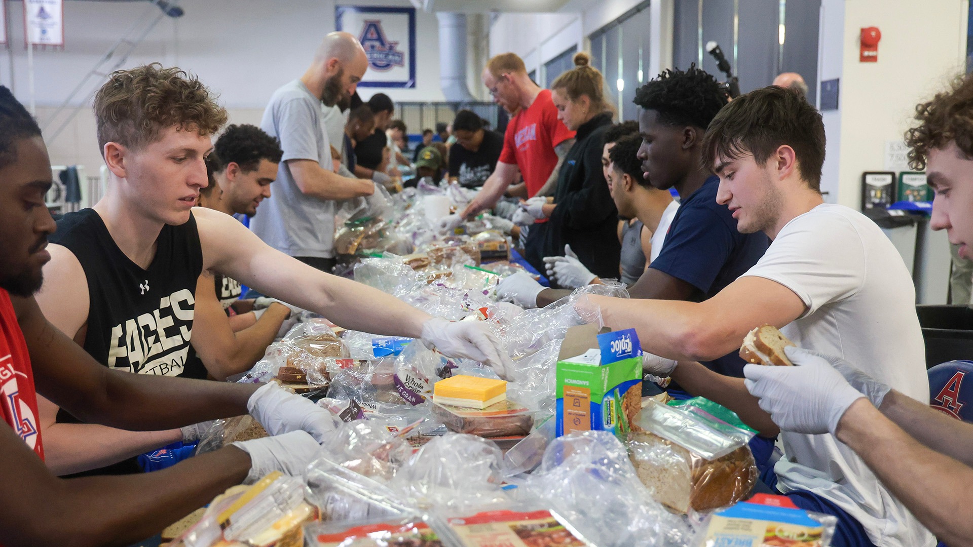 student-athletes making sandwiches as part of a service project with Athletes for Hope