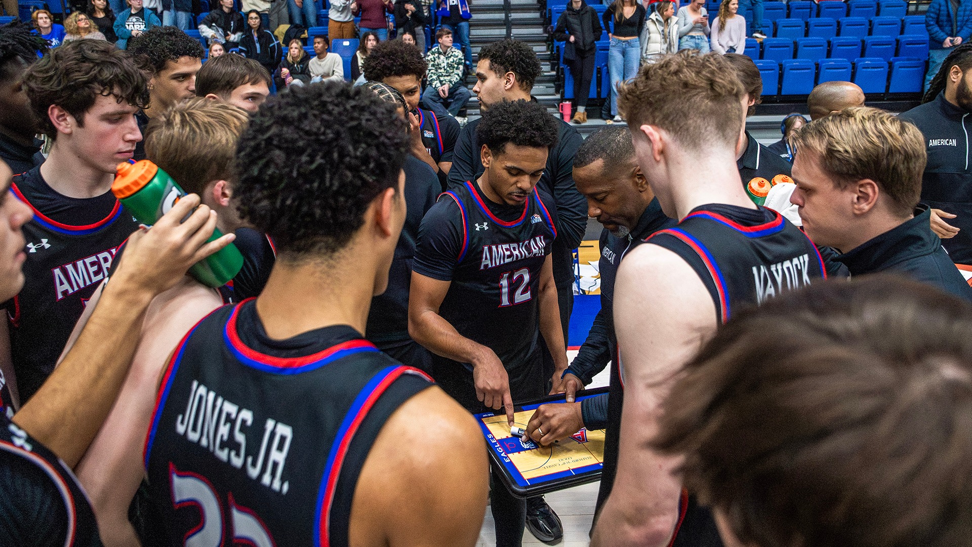 Men's basketball teams huddled up pregame with coach Duane Simpkins
