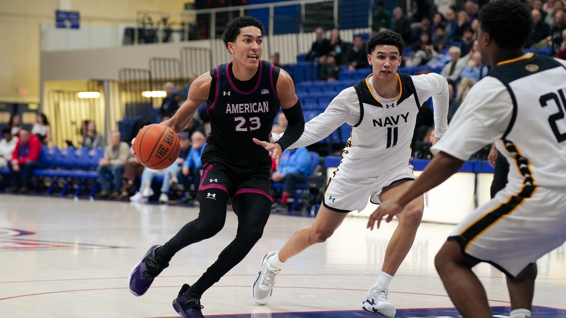 Greg Jones driving the lane with the ball during a men's basketball game against Navy
