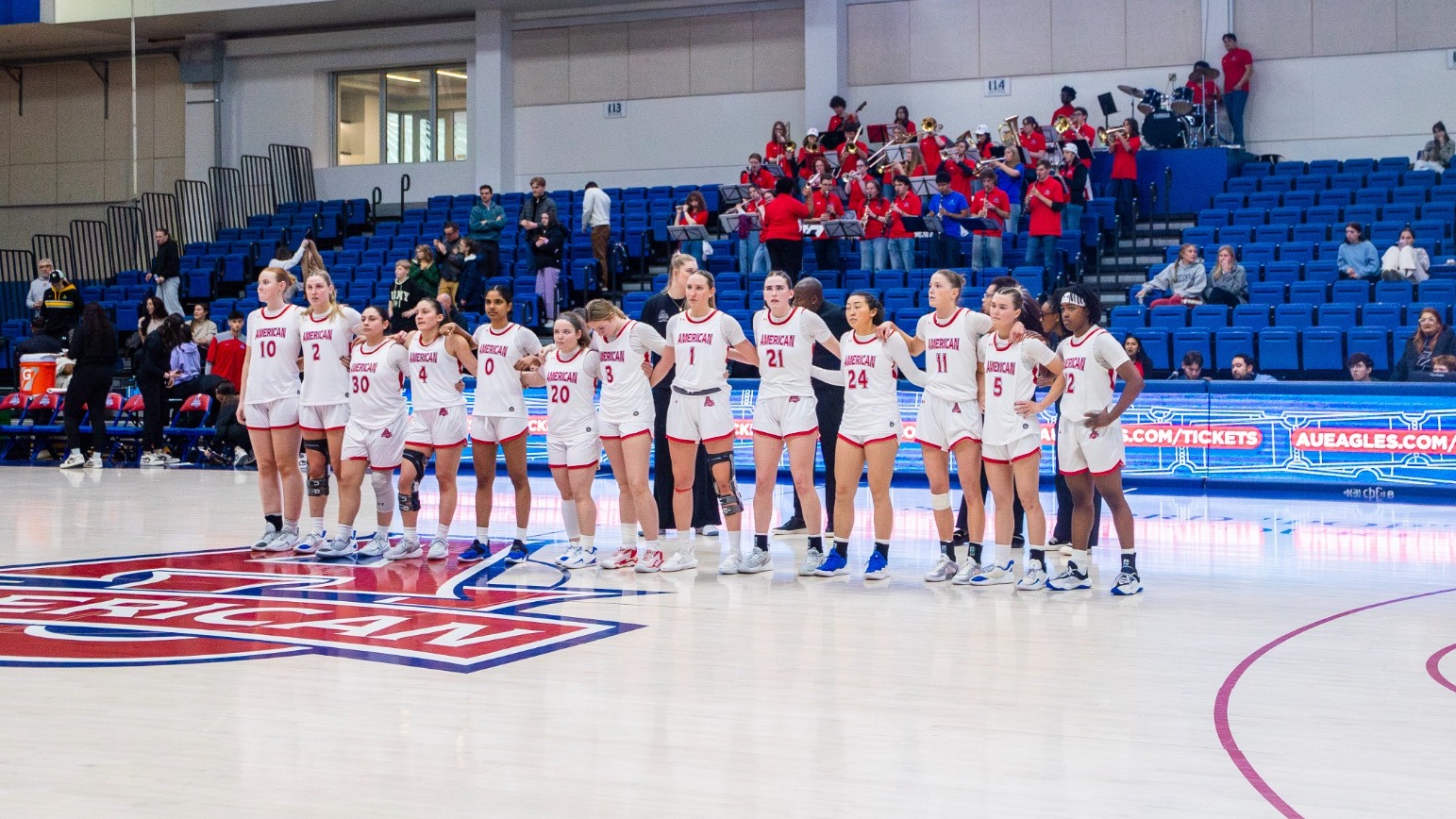 Women's basketball lines up on center court postgame to thank fans. 