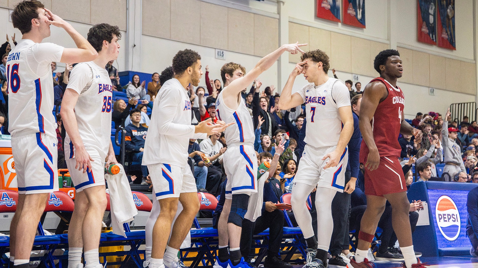 Wyatt Nausadis and bench celebrating a big three-point shot in a men's basketball win against Colgate