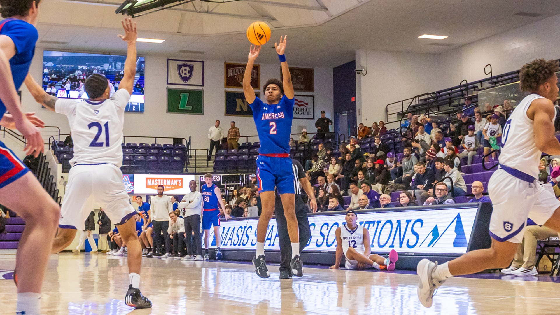 Madden Collins taking a long shot in a men's basketball game at Holy Cross