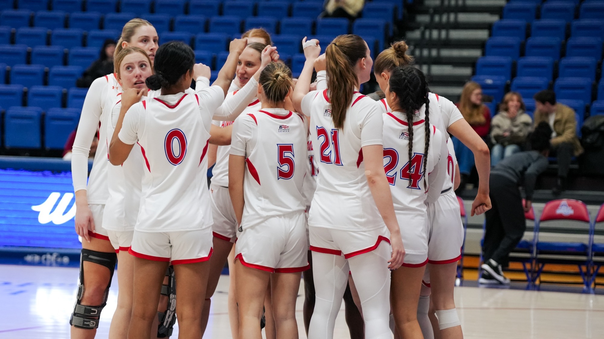 Women's basketball huddles on the court pregame against the visiting Crusaders of Holy Cross.
