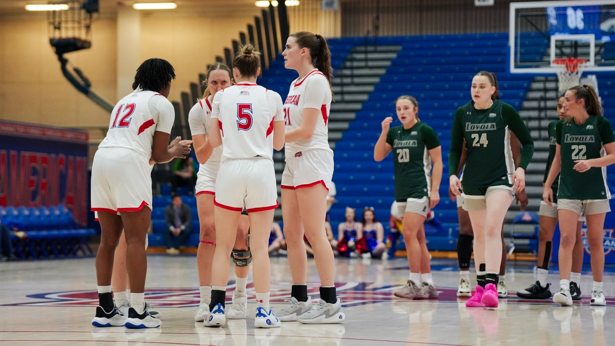 Women's basketball huddles together on the court against Loyola.