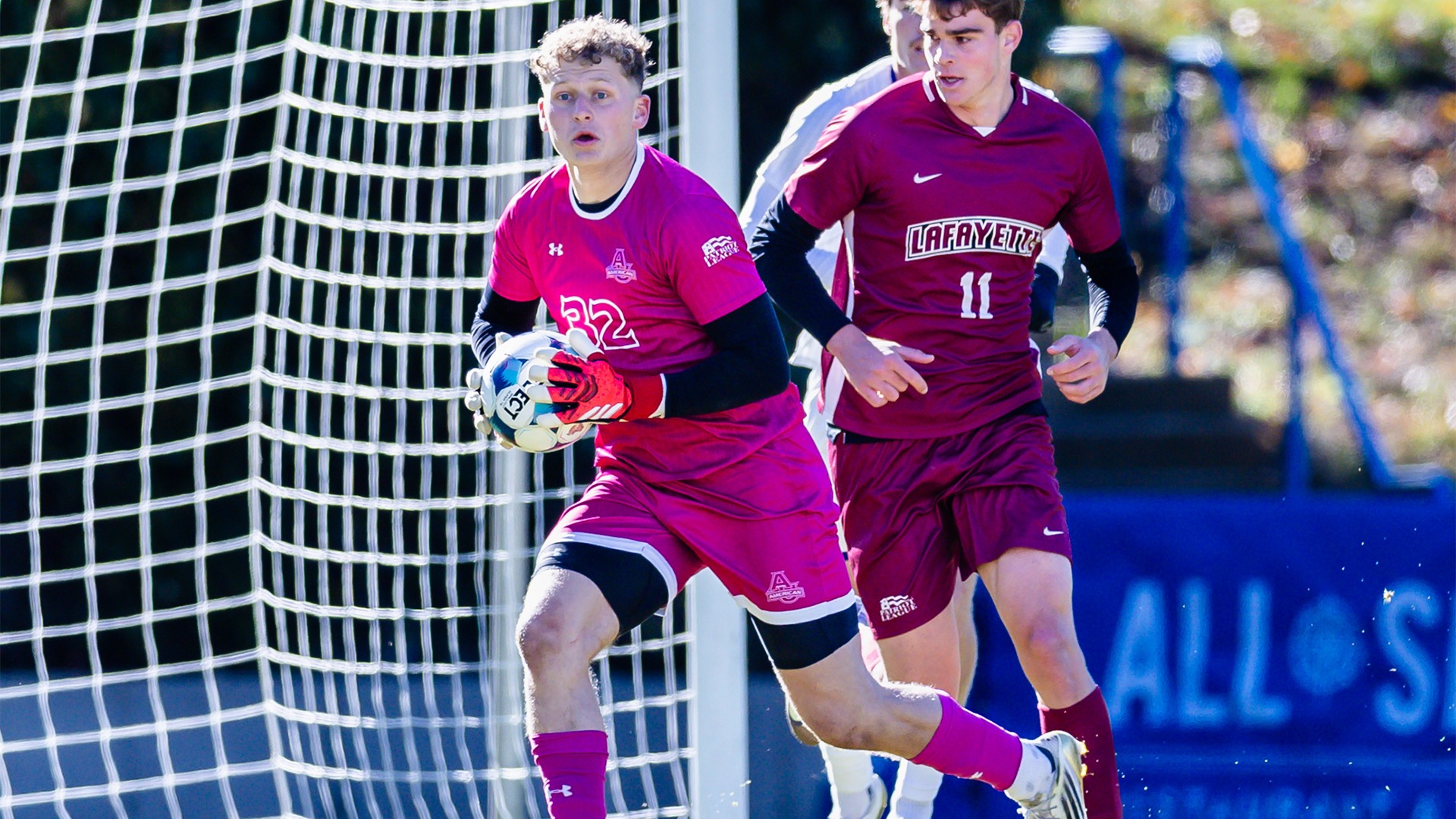 Matthew Tibbetts running with the ball after making a save in a soccer match against Lafayette.