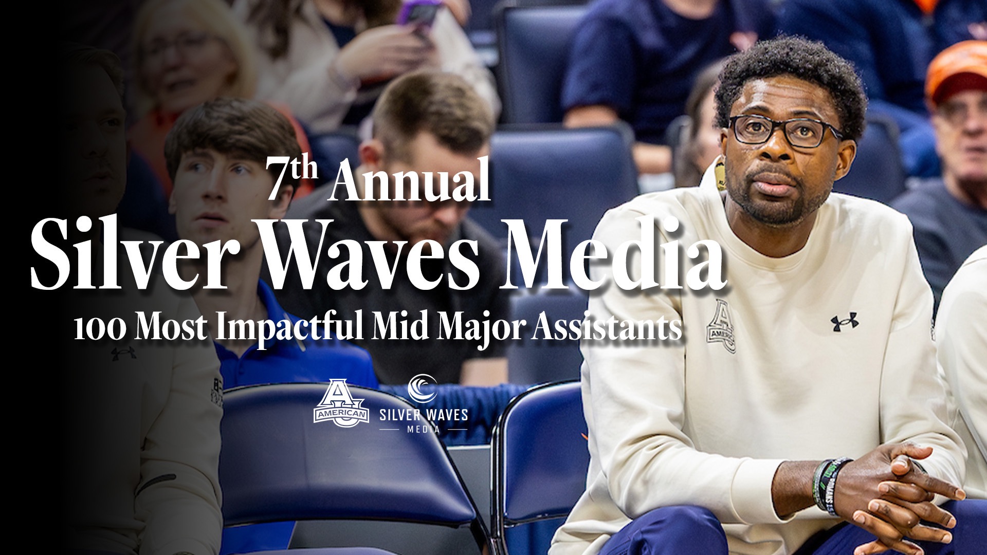 Jackie Manual on the men's basketball bench with his honor of being named to the Silver Waves Media 100 Most Impactful Mid-Major Assistants written on the graphic