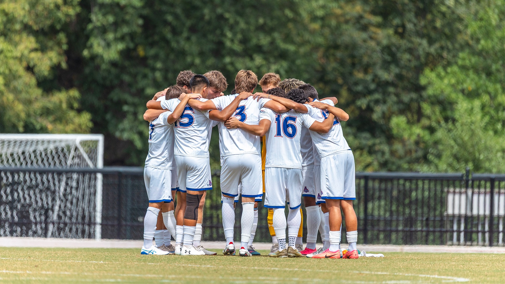 The men's soccer team huddled before a match.