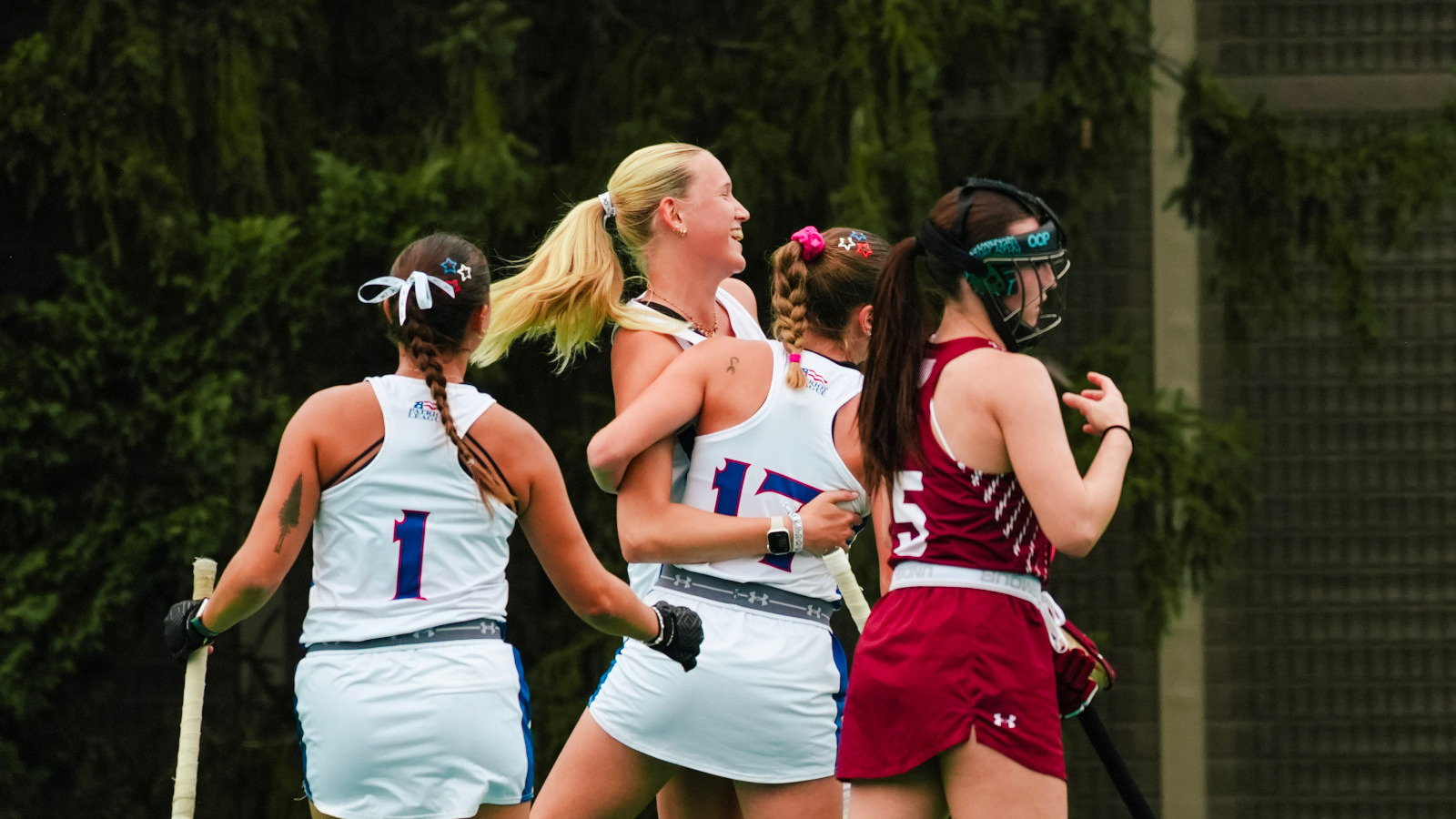 Emilia Winkler and Jordan Reicher celebrate with Sophie Willemse after she scores a goal.
