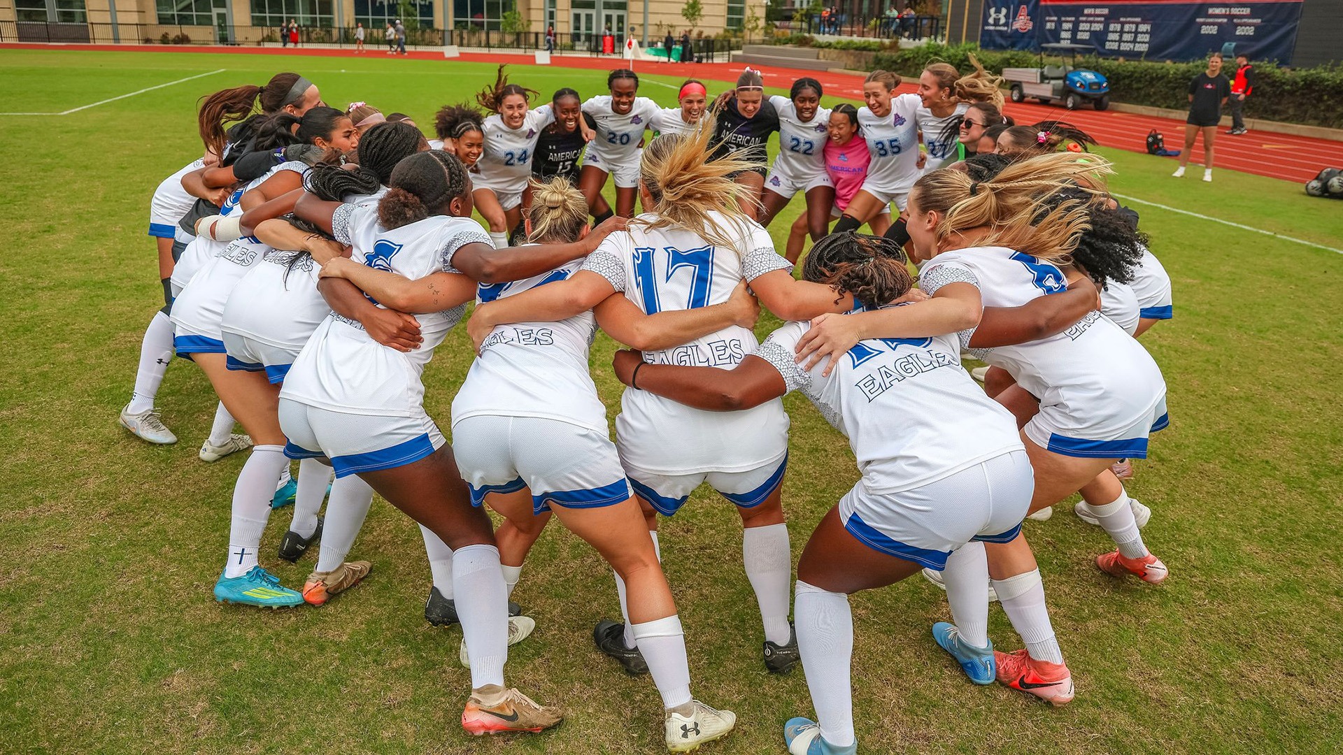 women's soccer team huddled and cheering before a game