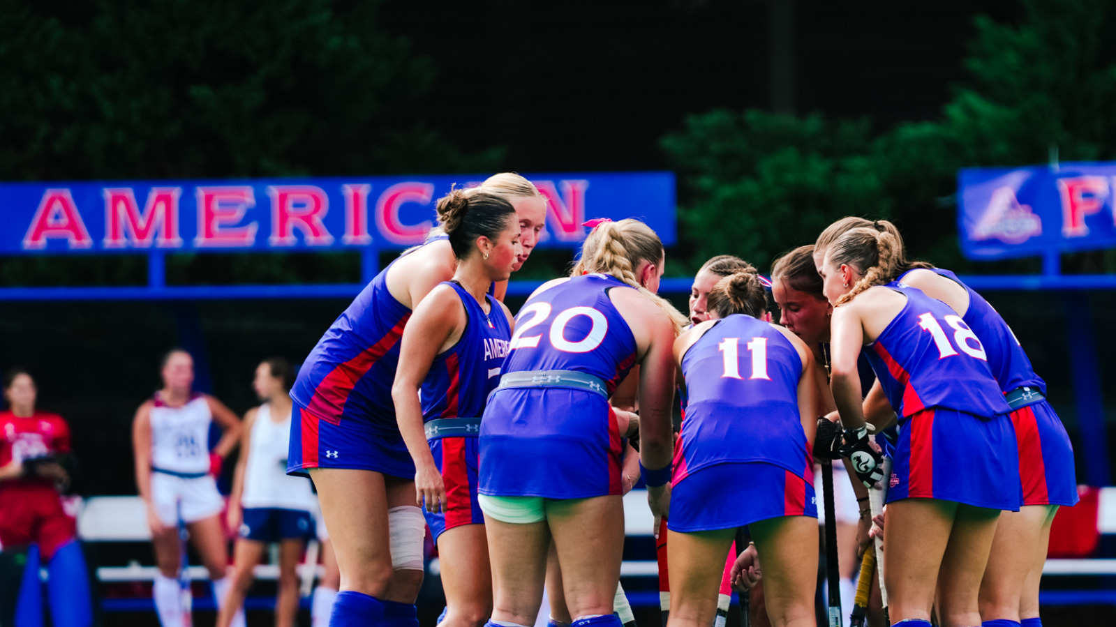 Field hockey huddles together before a penalty corner. 