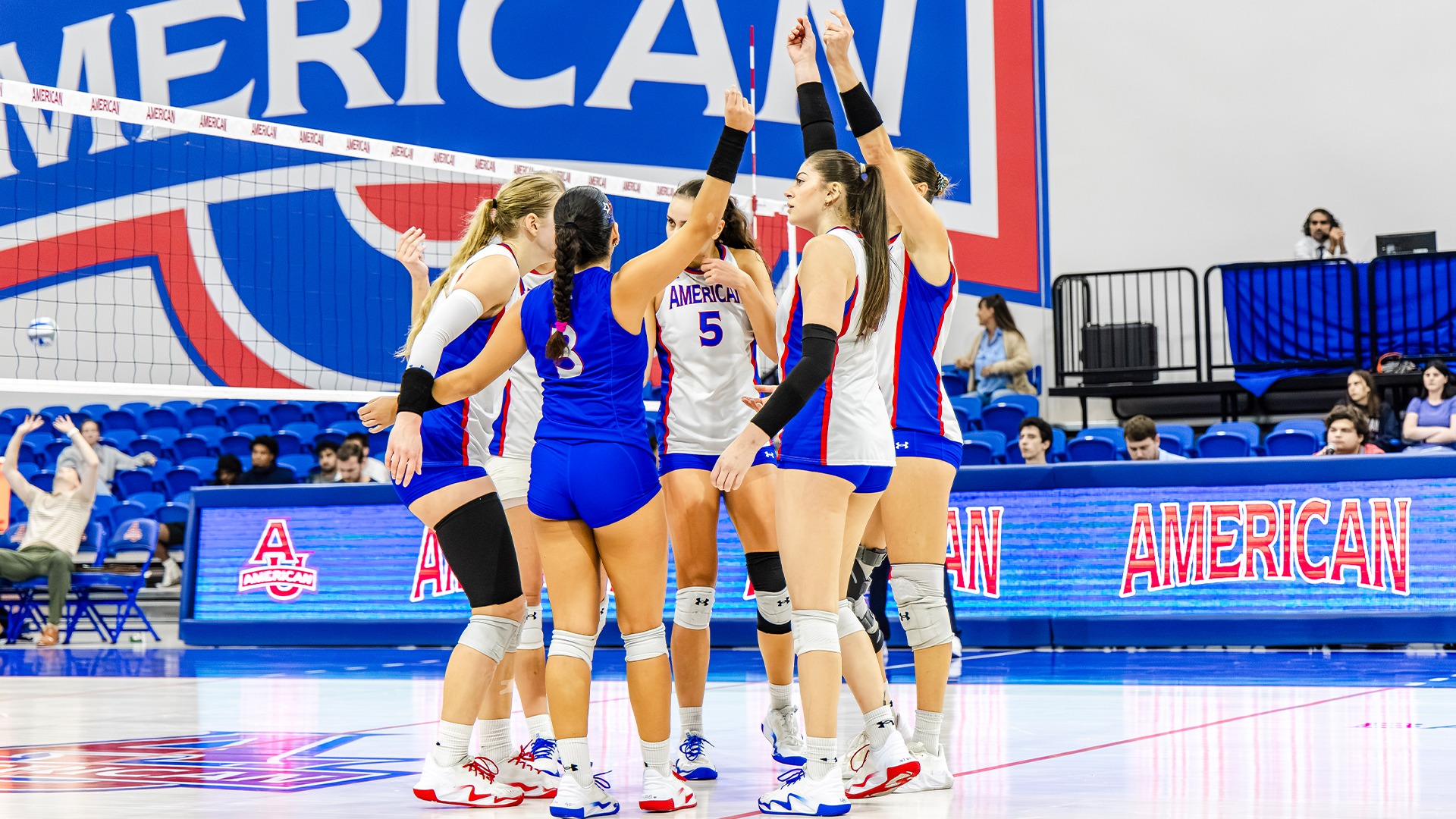 The volleyball team celebrating a point. 