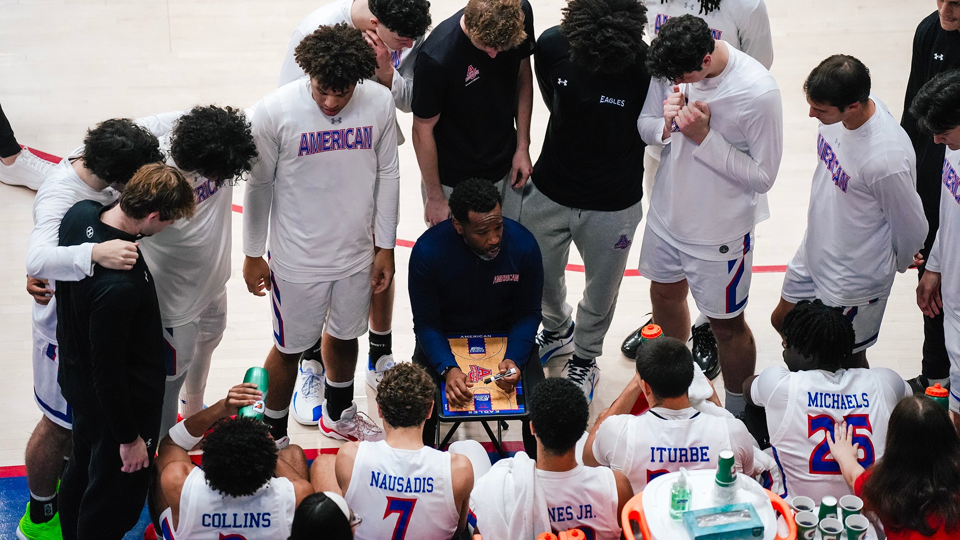 men's basketball timeout with Coach Simpkins talking to the team