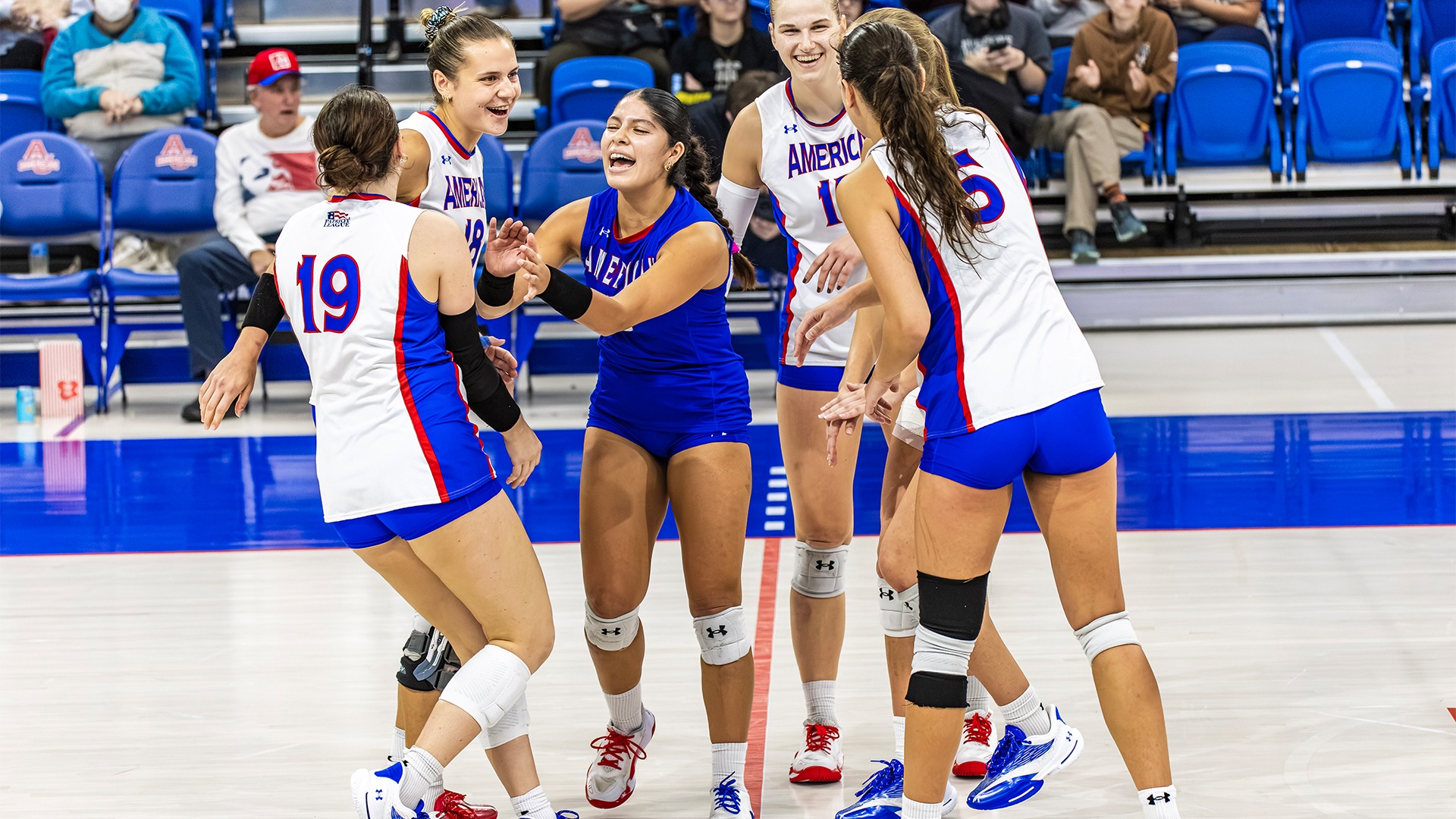 The volleyball team celebrating a point.