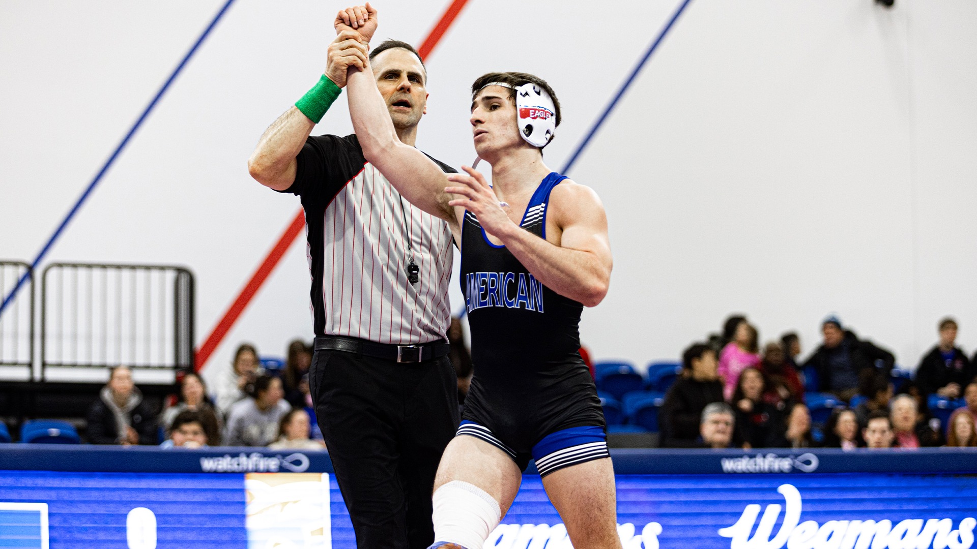 Jack Maida getting his arm raised after winning a wrestling match.