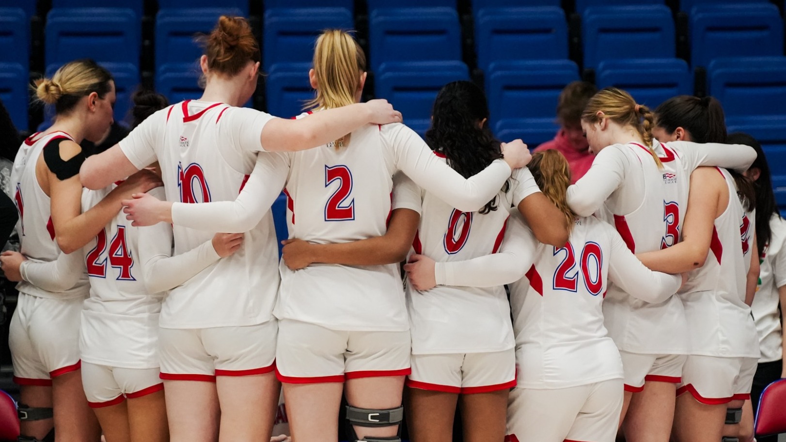 Women's Basketball team huddles together during a timeout.