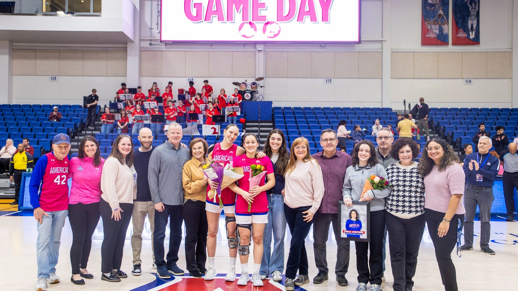 The Eagles' three seniors–Emma Winters, Laura Nogues, and Anna Rescifina–posing with family and friends at midcourt.