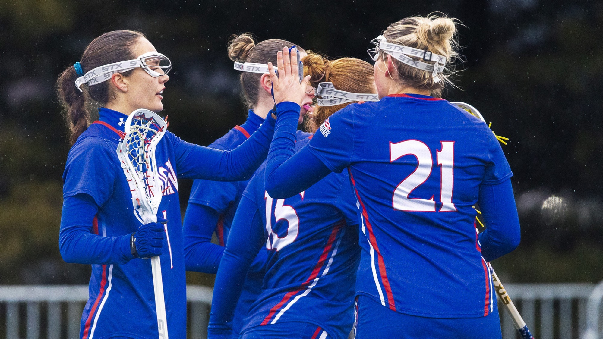 Adria Kotzian and Kellie Linehan high-fiving after scoring a goal against Howard.