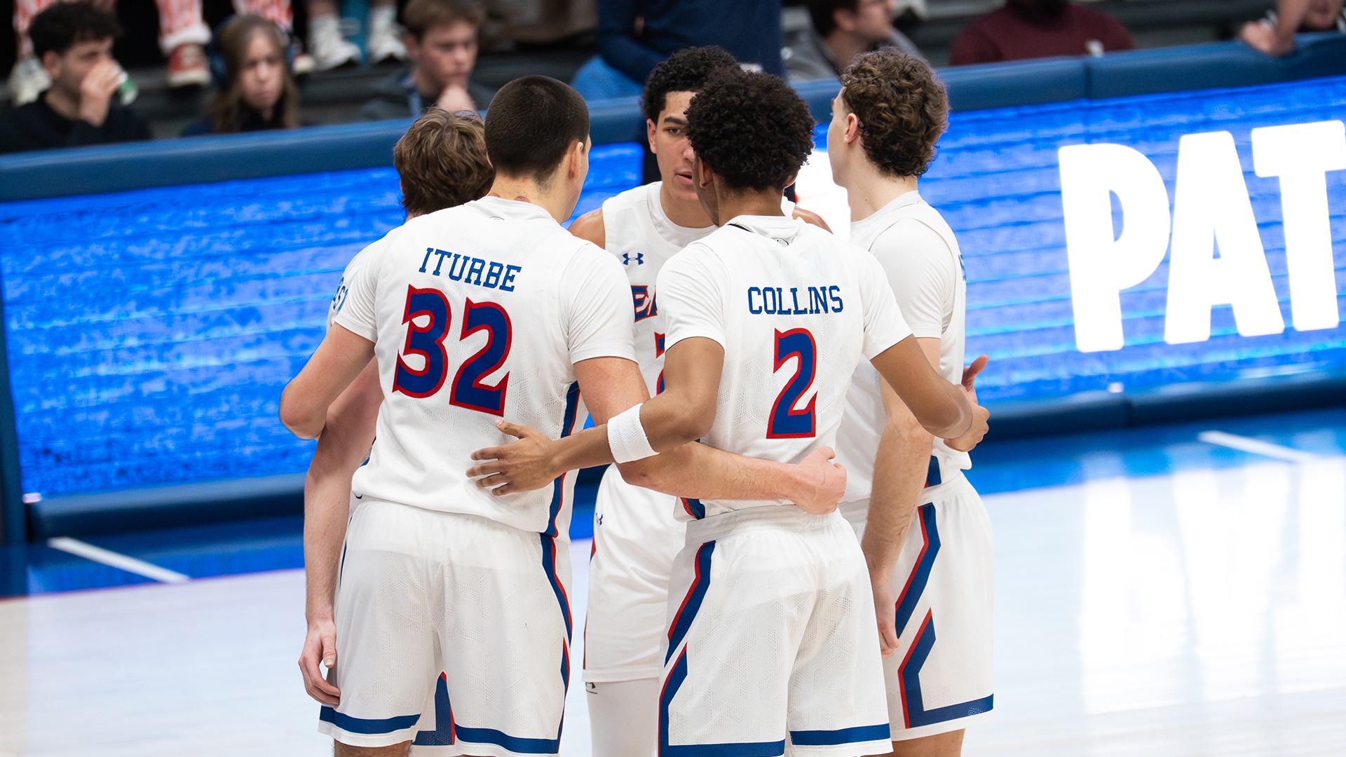 men's basketball players huddled during a game