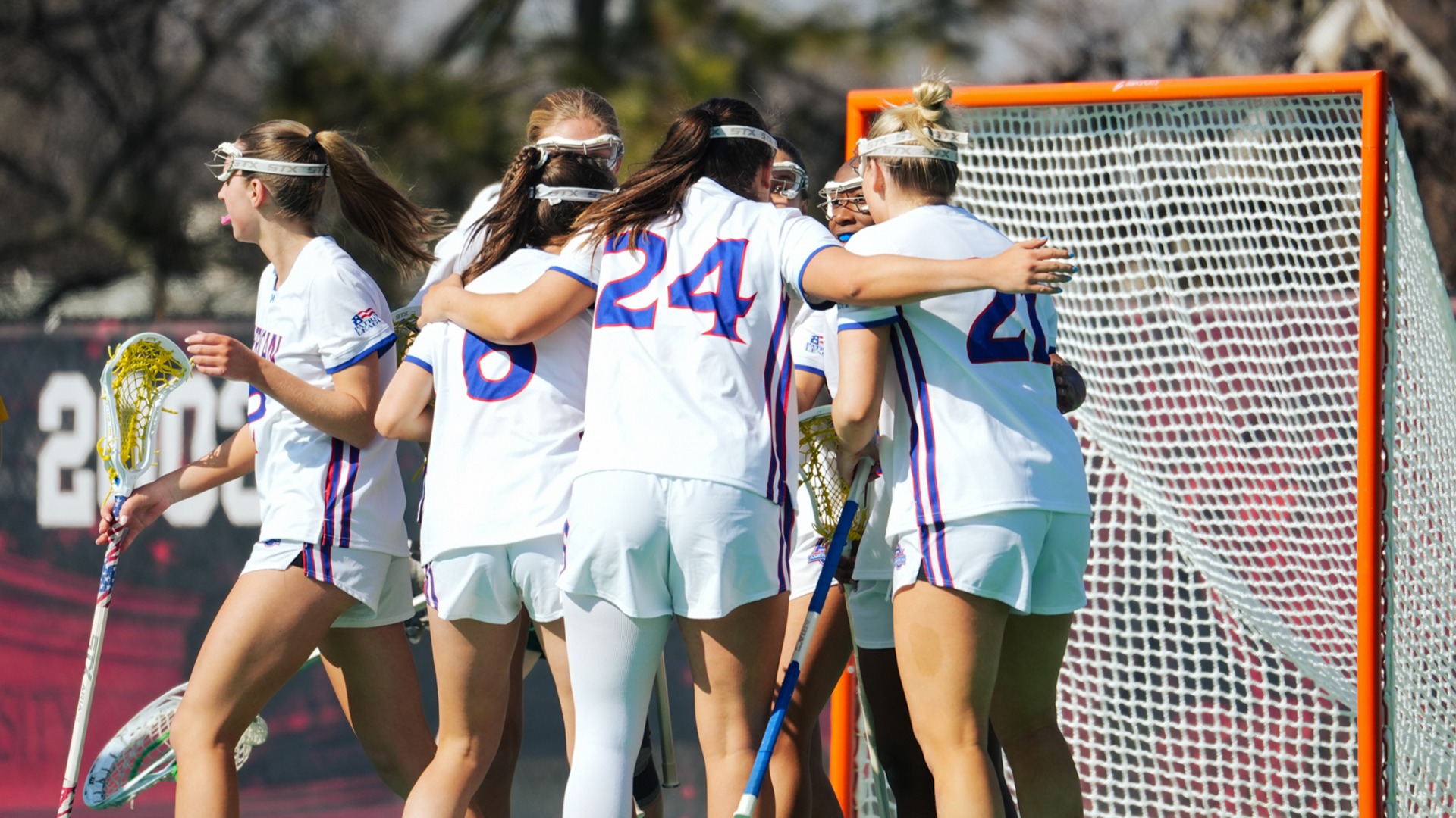 Reagan Murdoch in a huddle with her teammates during a lacrosse game against George Mason.