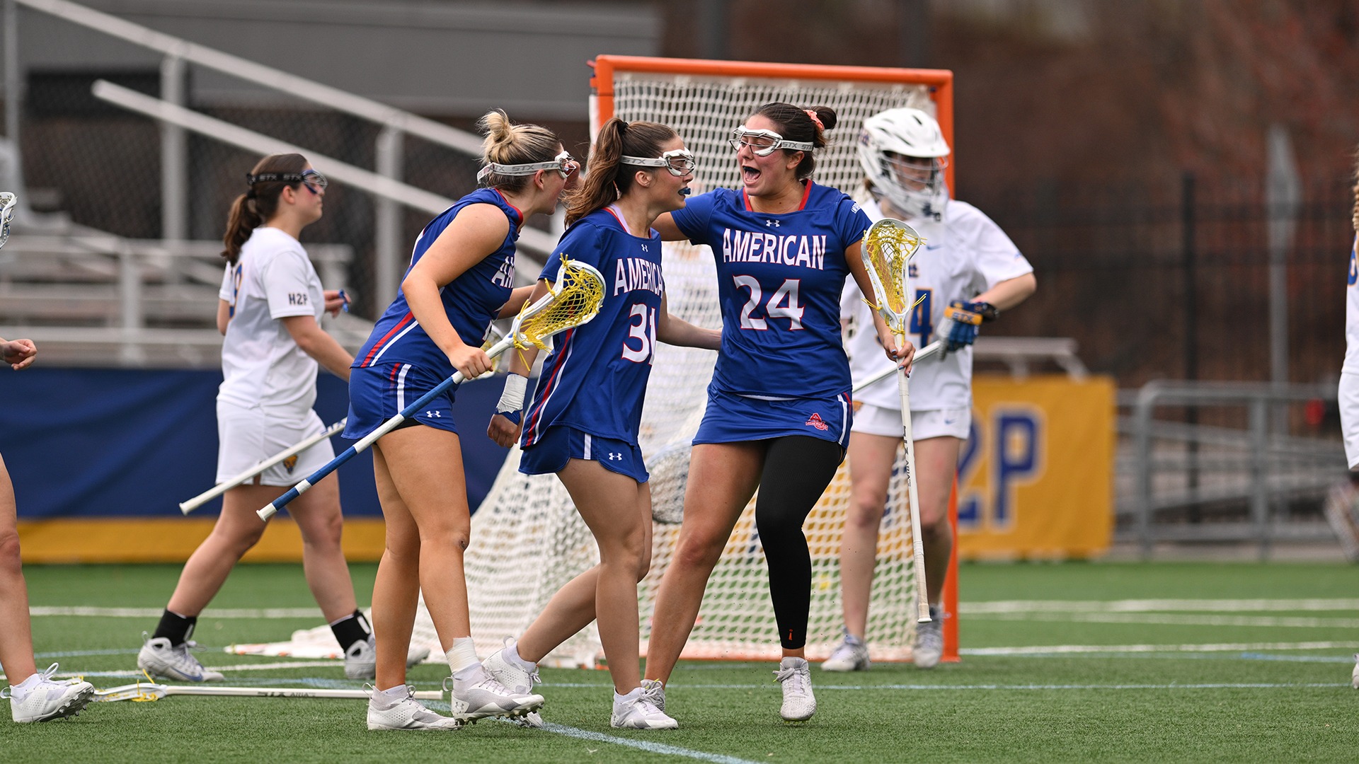 Shannon Solvius, Reagan Murdoch, and Kellie Linehan celebrating a goal in a lacrosse game against Pittsburgh. 