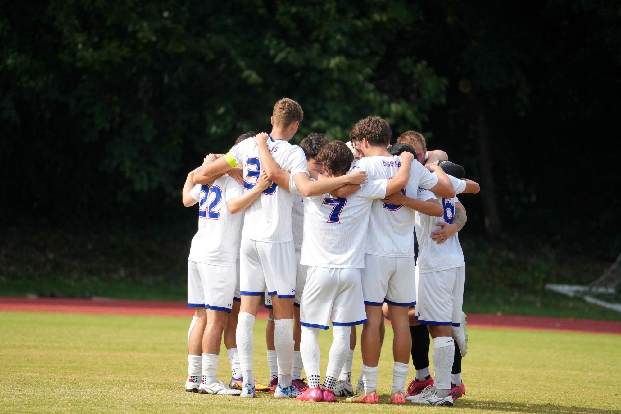 The men's soccer team in a huddle before a game.