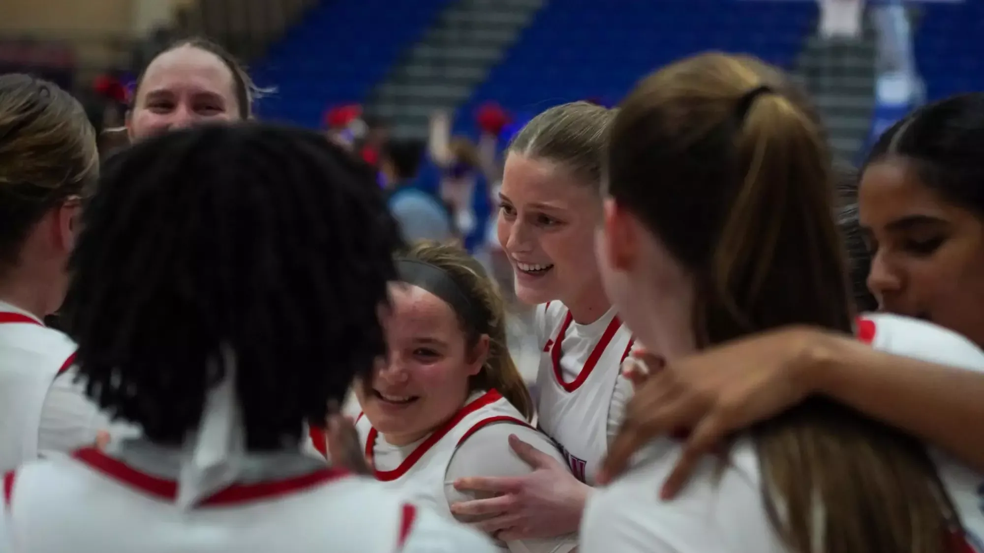 Mary Bolesky and Elizabeth Archer in a women's basketball huddle during a game.