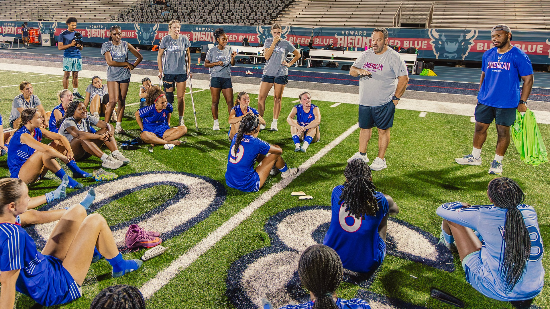 Phil Casella talking to the women's soccer team after a game