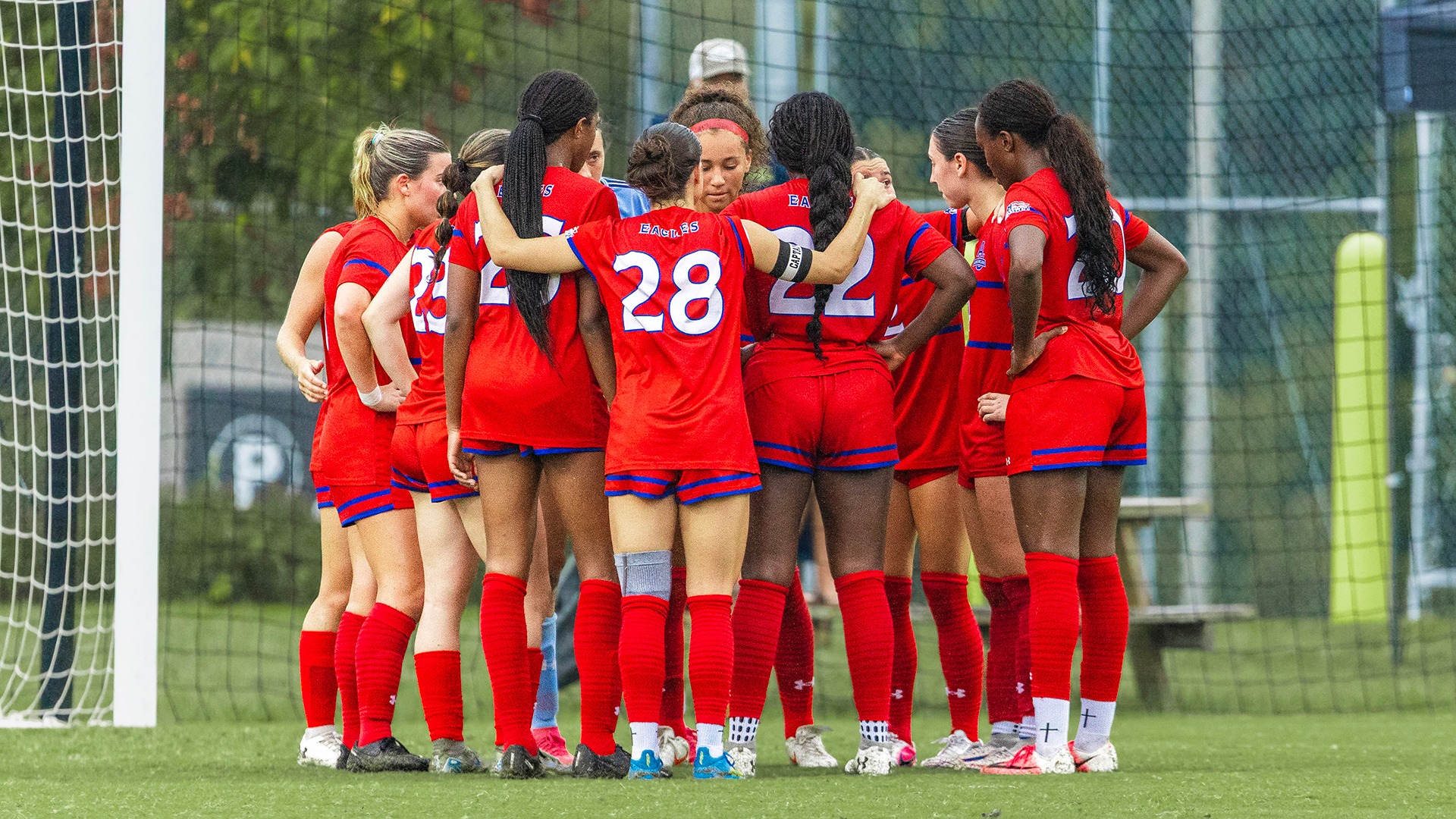 women's soccer players huddle up before a game at UMBC