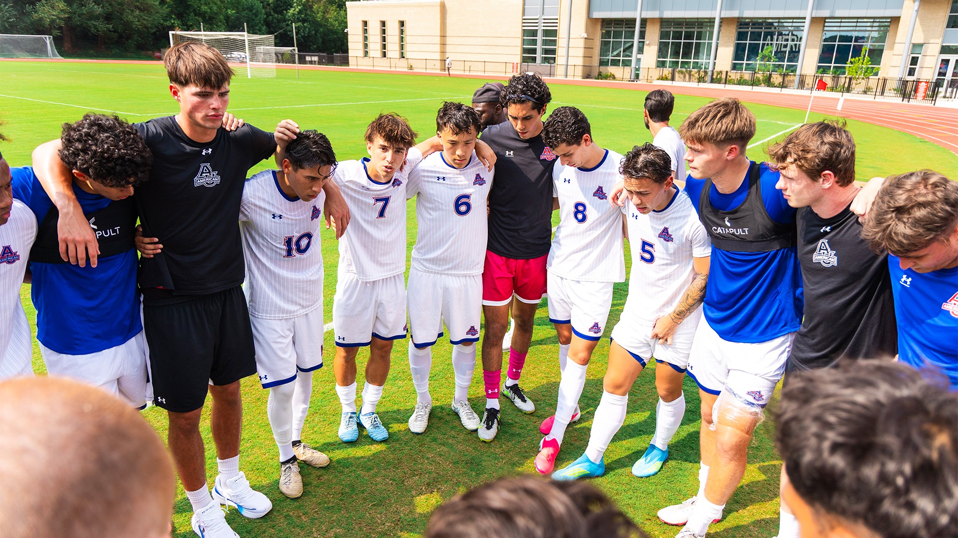 Men's soccer in a huddle. 