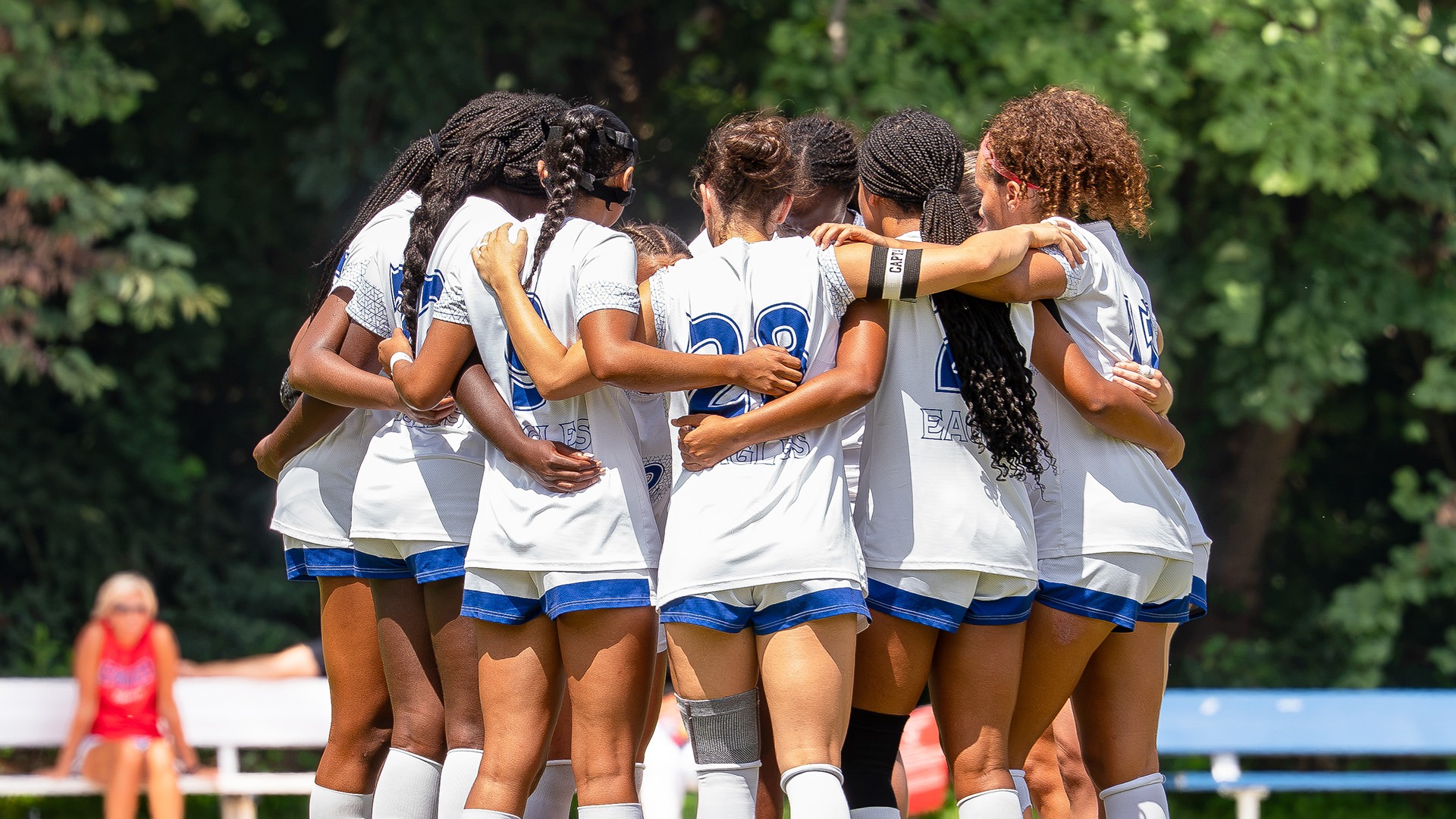 women's soccer players huddled during a home game
