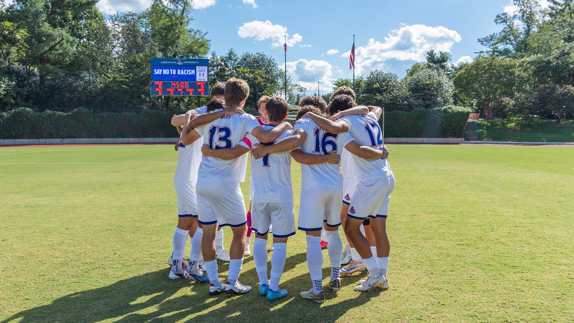 The men's soccer team in a huddle. 