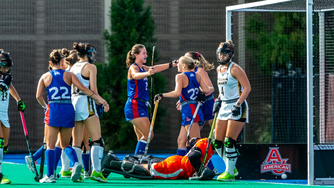 Jill DuVarney celebrating a goal in front of the goal with teammates.