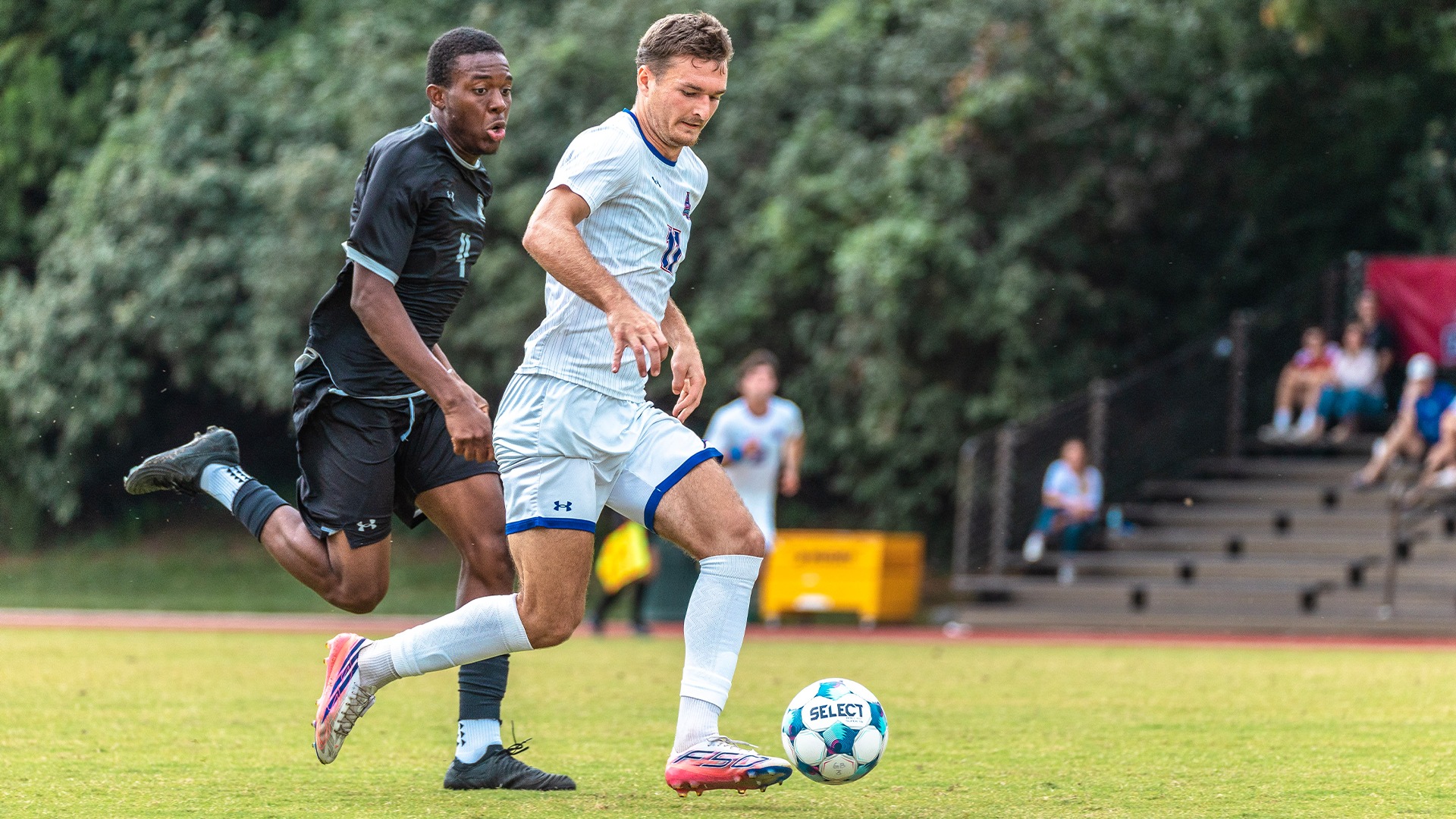 Patryk Rojek dribbling in a soccer match against Loyola Maryland.