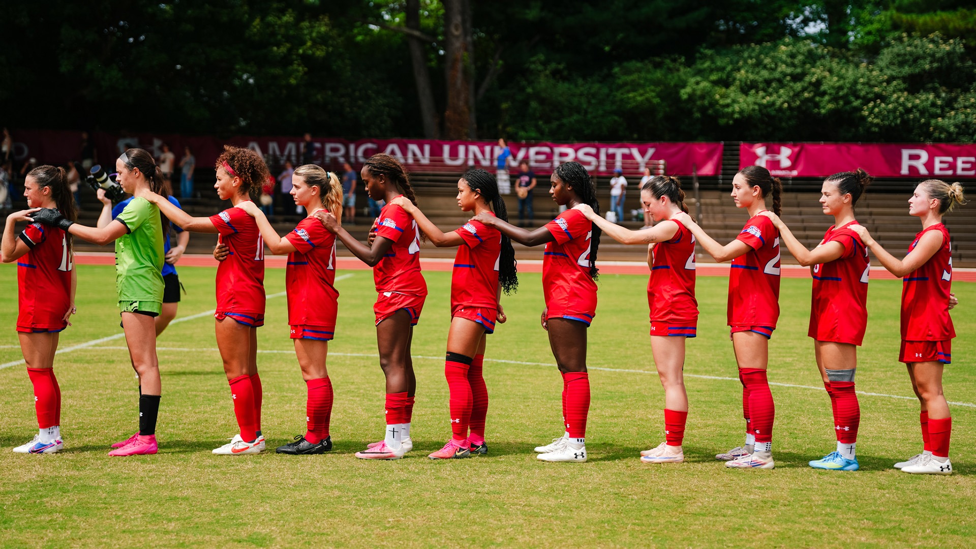 women's soccer players lined up during the national anthem