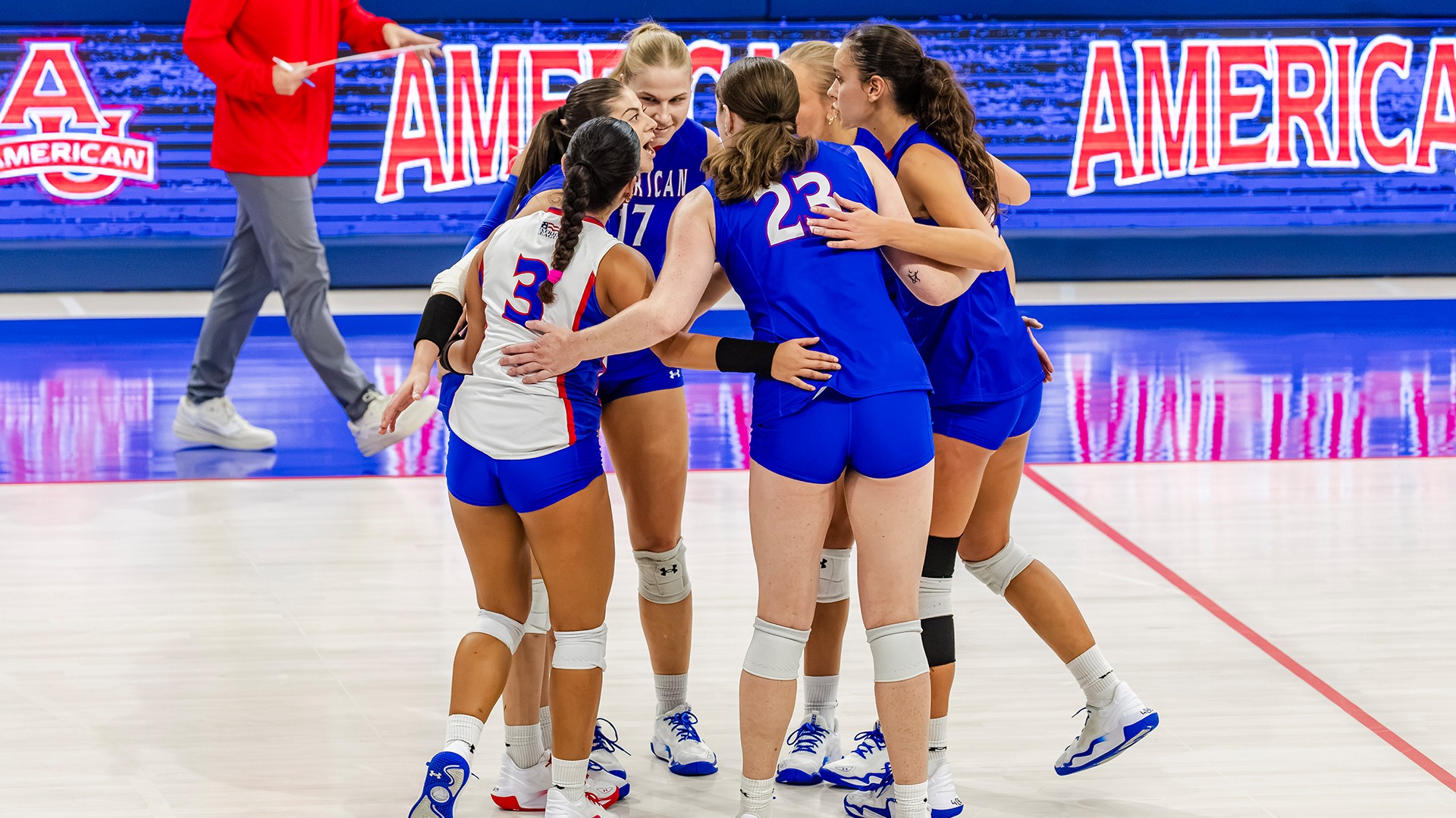 The volleyball team in a huddle. 