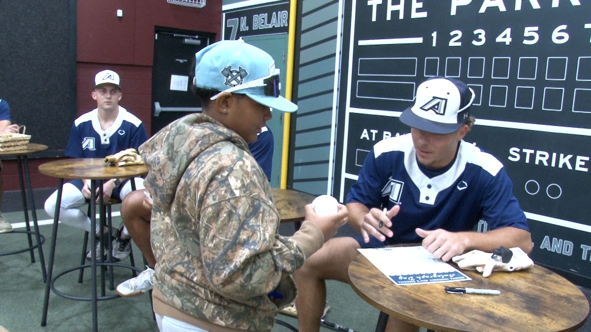 Augusta University baseball players sign autographs for a young fan