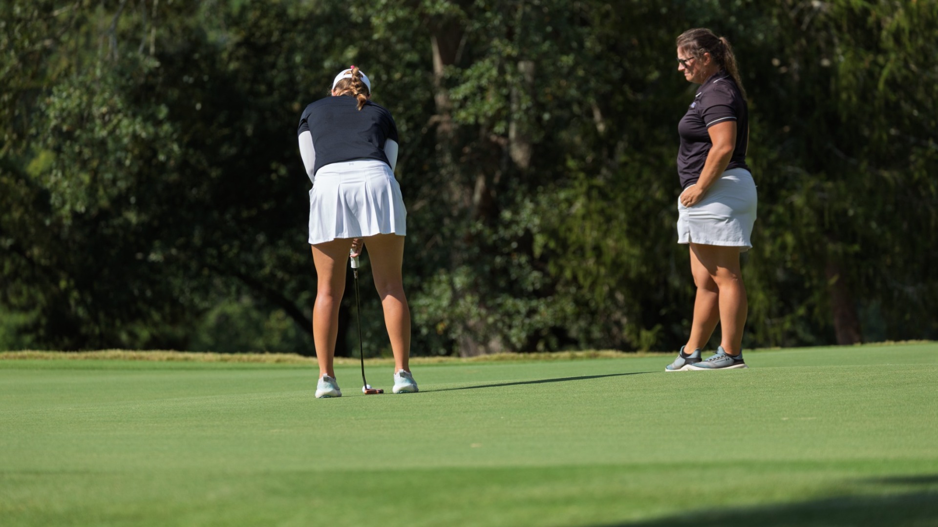 Augusta women's golf coach Ember Holloway looks on as Marine Legentil putts