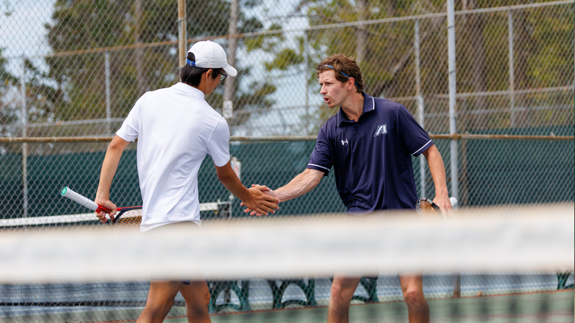 Men's tennis player Arthur Valette high fives Enzo Sakiyama