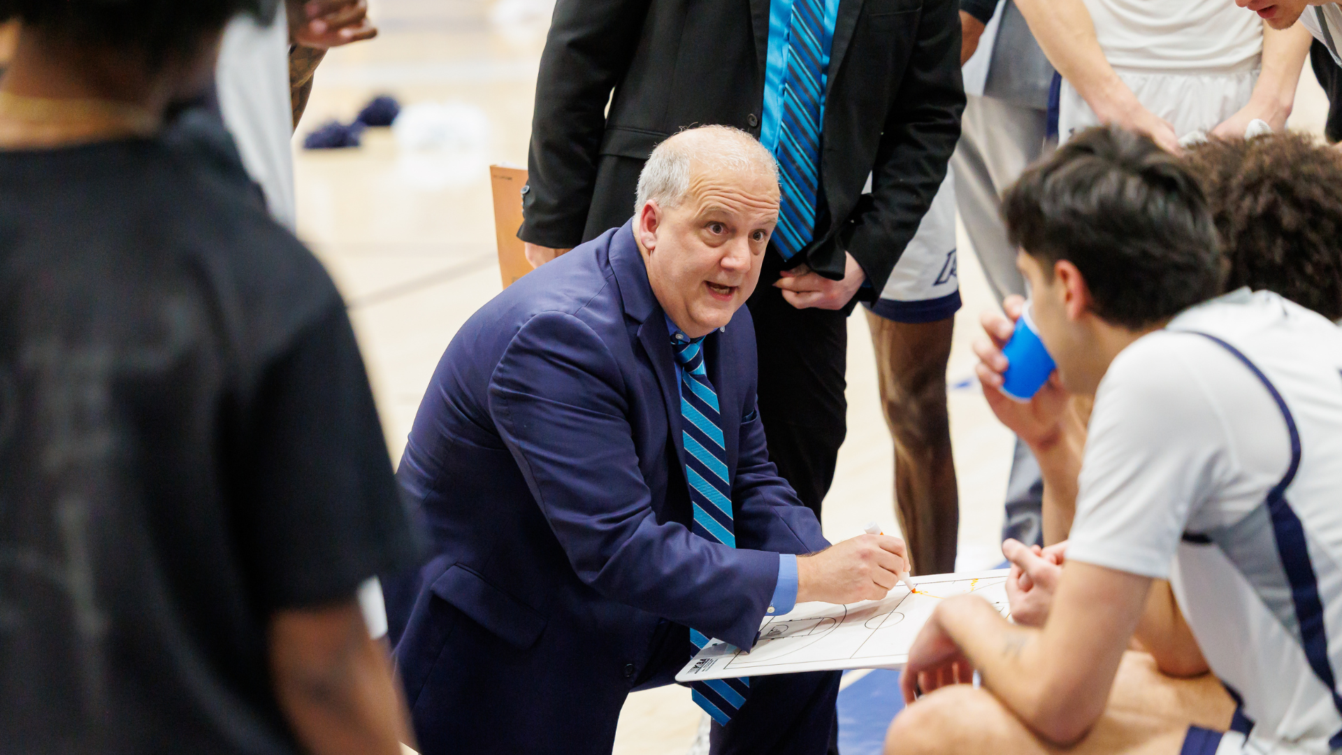 Dip Metress coaching in a timeout huddle