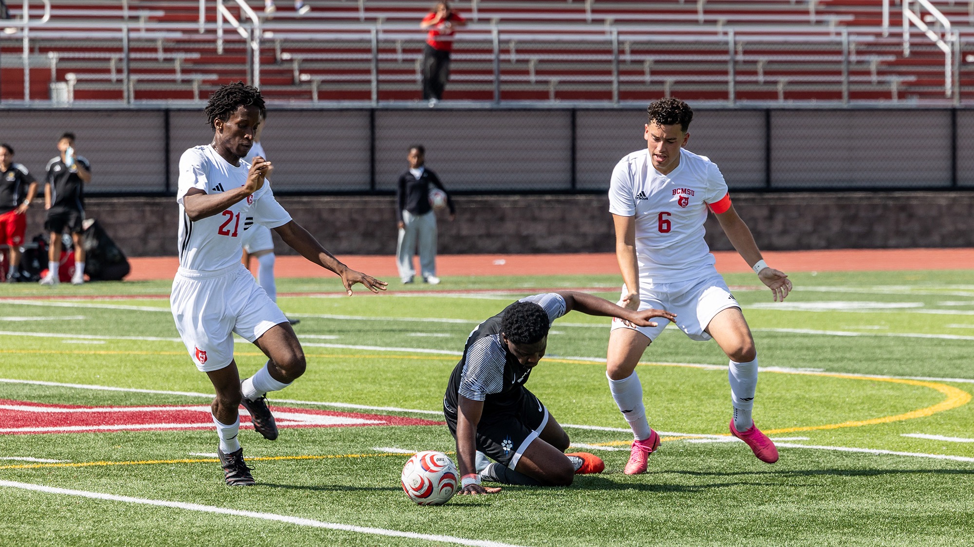 Bears soccer players chasing an opponent on the field