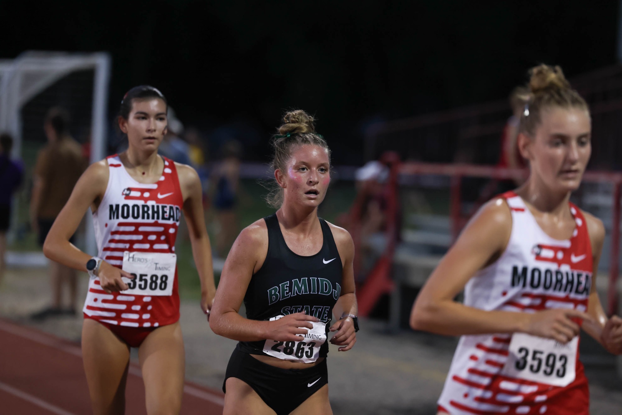 BSU Cross Country runner races in a black tank top with green and white letters. 