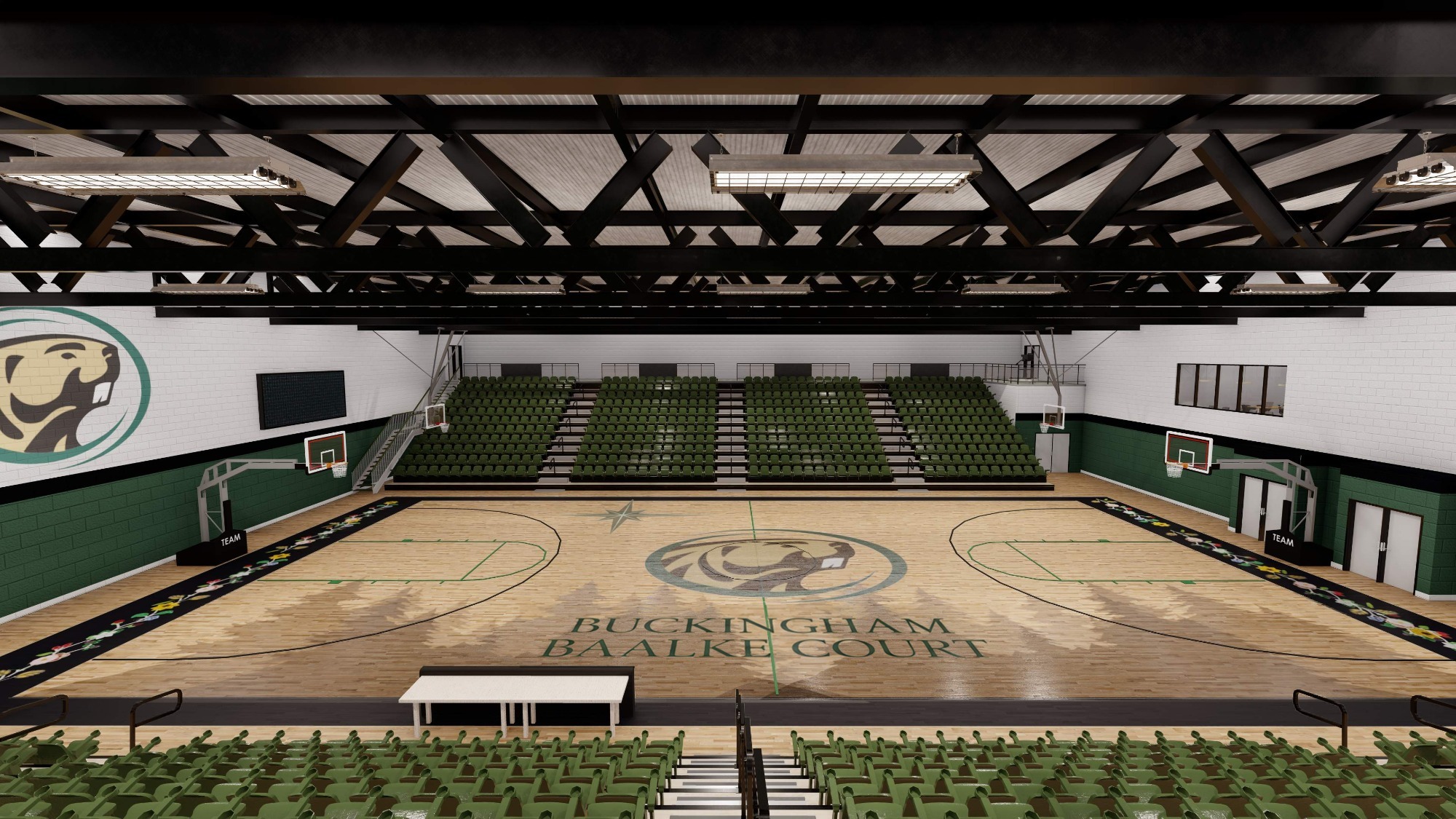 Wide view of an empty indoor basketball court labeled “Buckingham Baalke Court,” featuring green seating, two hoops, and a wood floor with a center logo under exposed ceiling beams.
