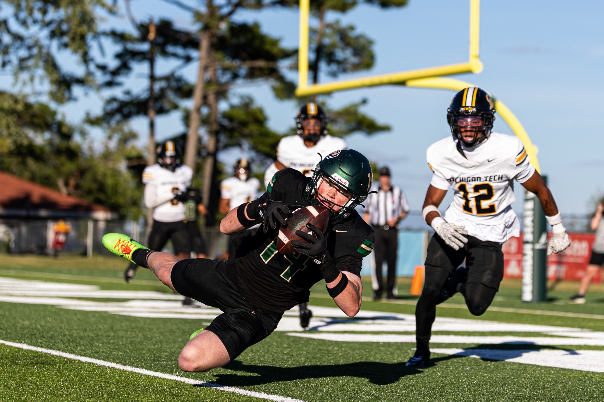 Bemidji State football player dives forward with the football near the goal line as a Michigan Tech defender closes in during a game.