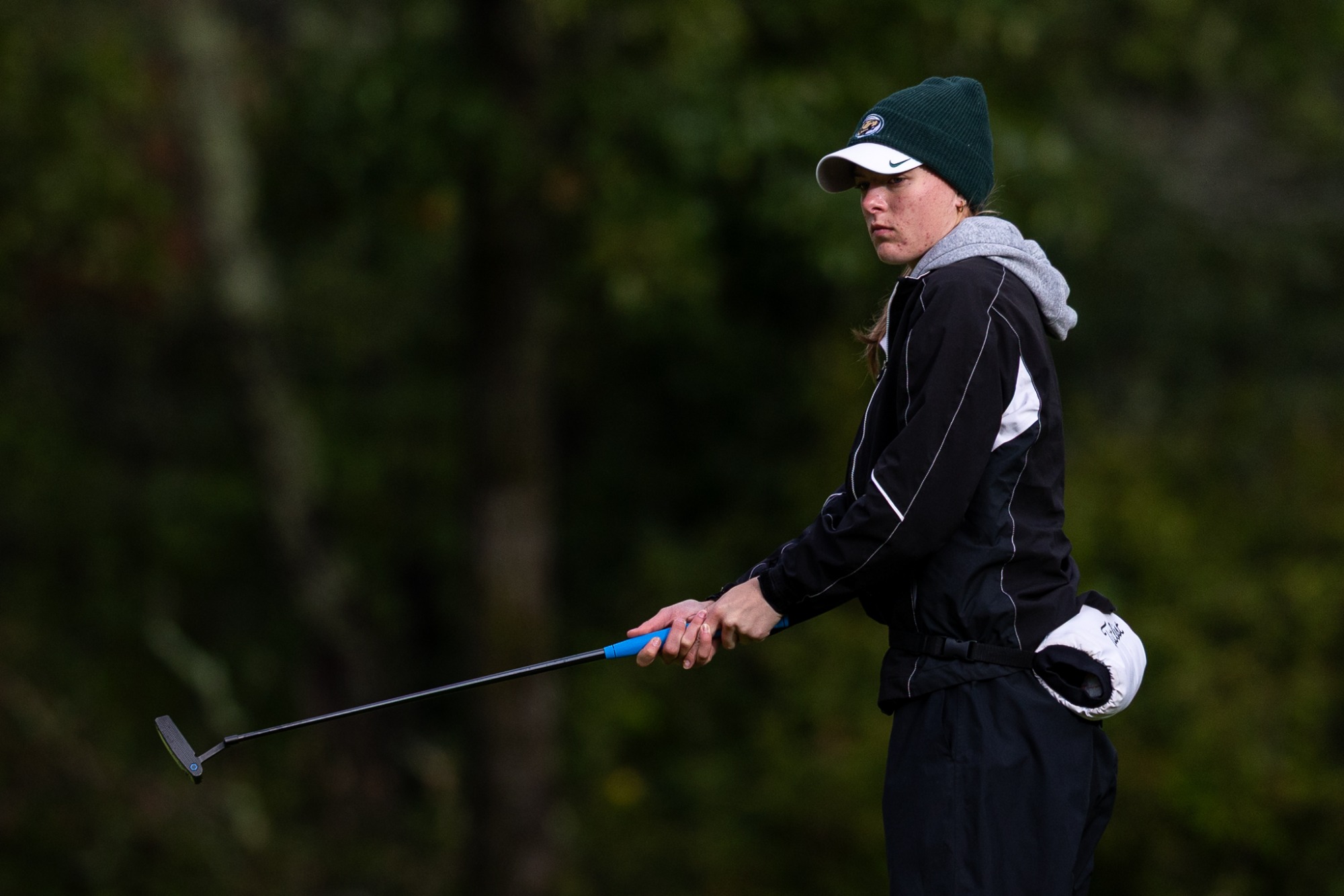 Lauren Kammann holds a putter after completing a stroke on the green.