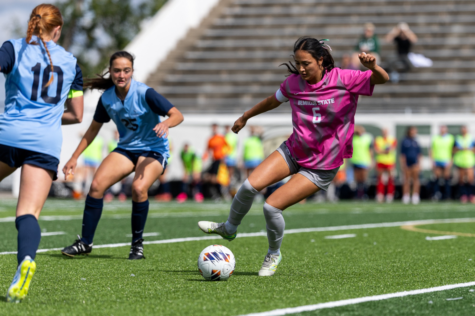 Bemidji State player No. 6 Megan Ko controls the ball between two Augustana defenders.