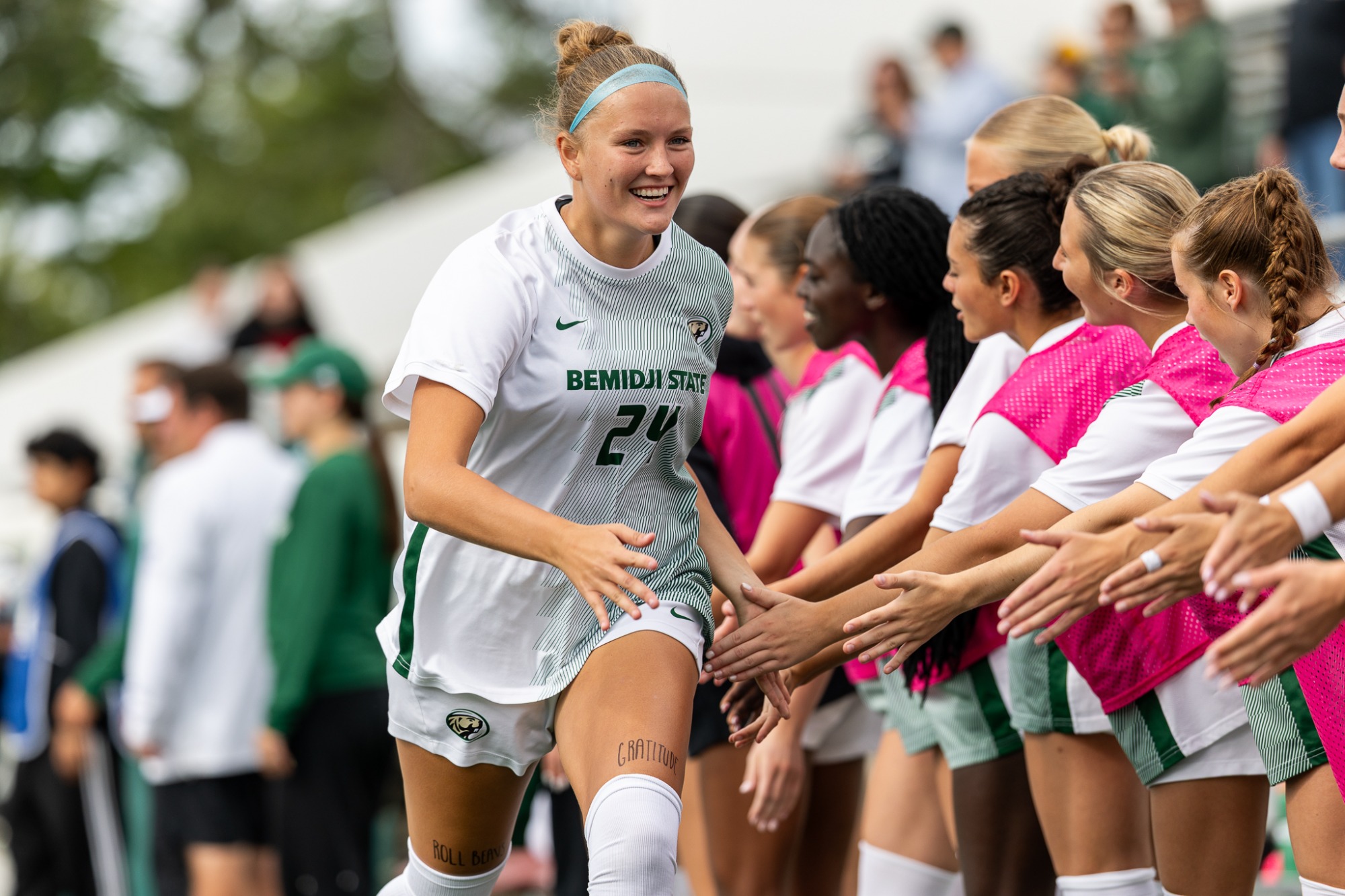 Grace Schwoch exchanges high-fives with teammates during pregame introductions before a match against Wayne State.