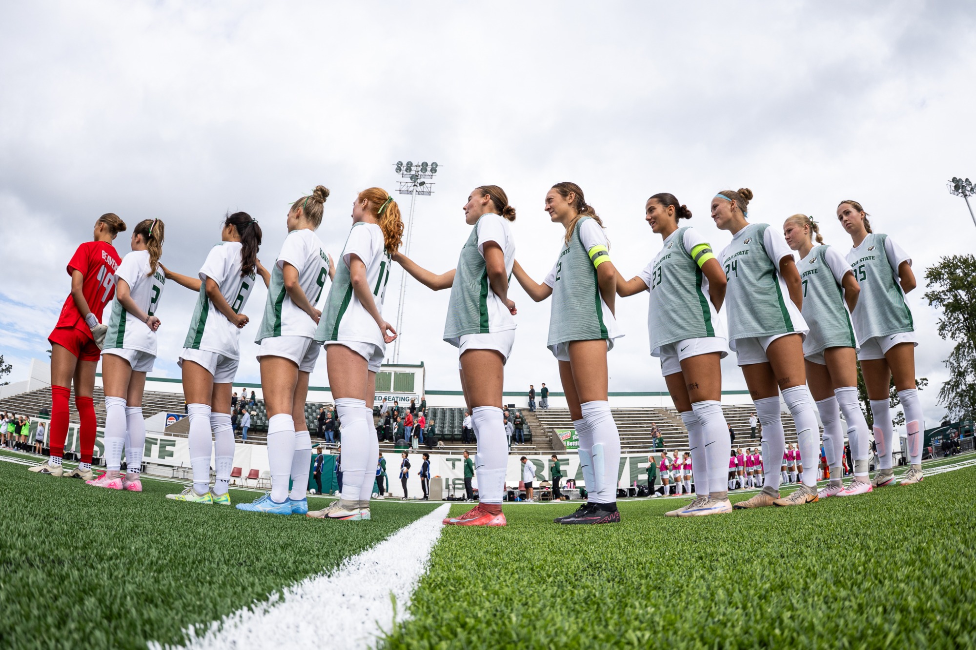 Wide-angle view of the Bemidji State starting lineup standing together during the national anthem at midfield.