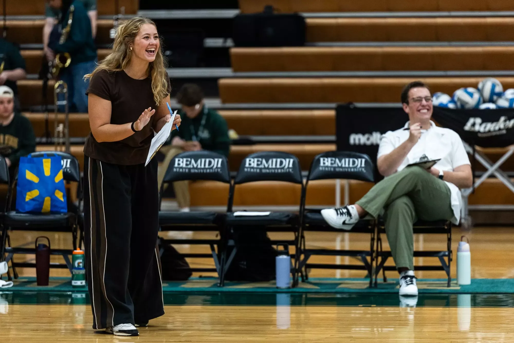 Hahni Johnson reacts from the sideline while holding a lineup board during a match against Northern State.