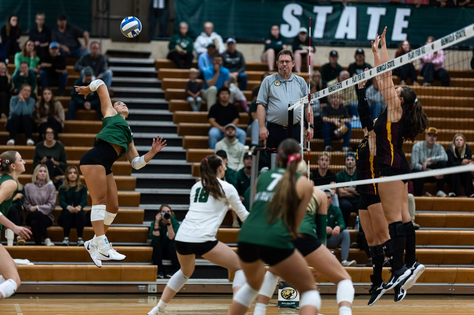 Ella Kratochvil (14) swings at the ball against two Minnesota Duluth blockers.